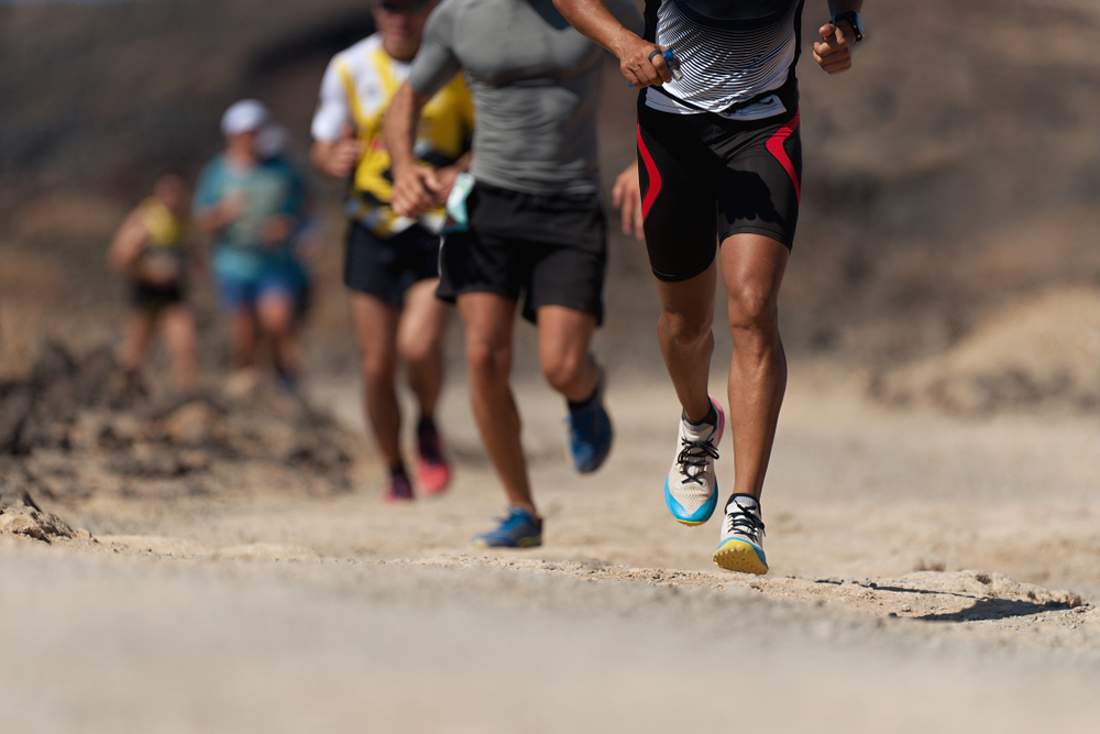 Coureurs participant à une épreuve d’ultra-trail sur terrain naturel accidenté, illustration d’un accident sportif et de l’information sur les assurances couvrant les dommages corporels.
